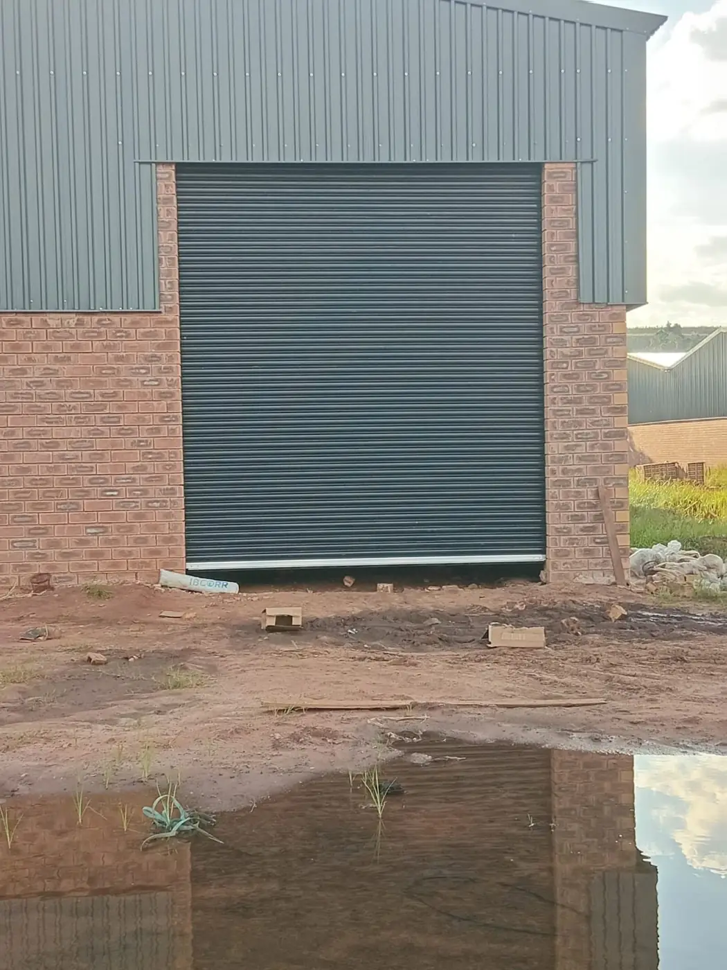 Charcoal colour-coated industrial roller shutter door installed on a factory unit in Gauteng